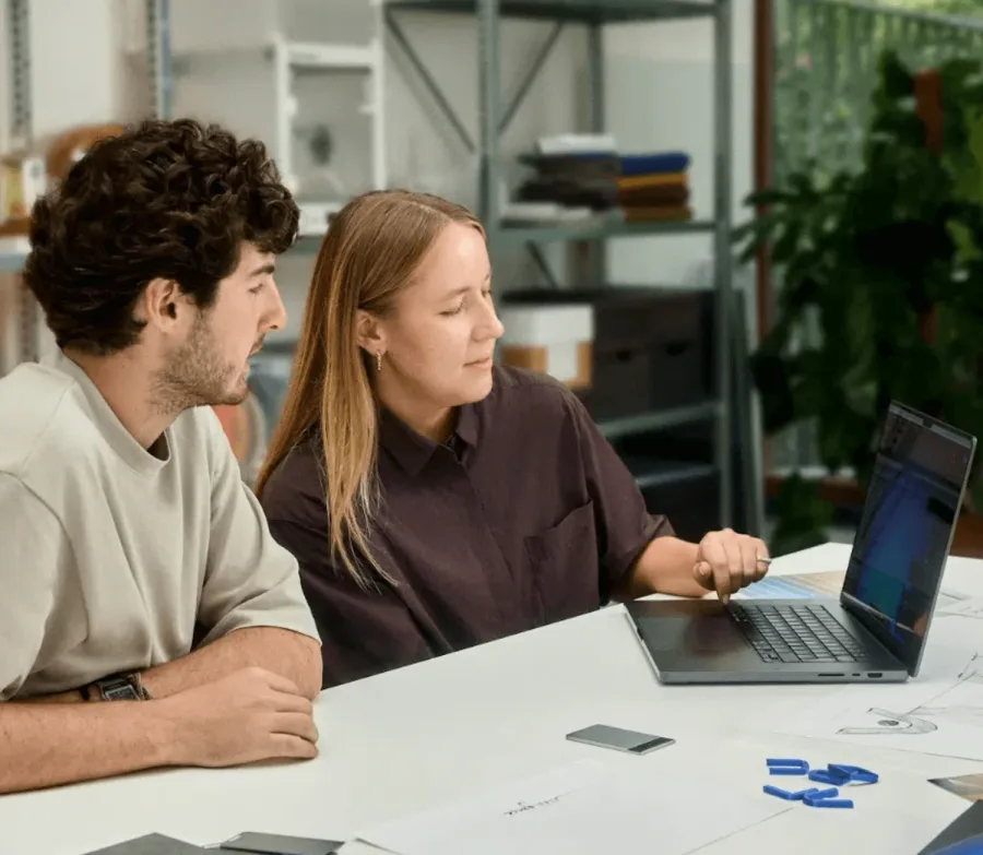 Мужчина и женщина обсуждают запись рядом с ноутбуком